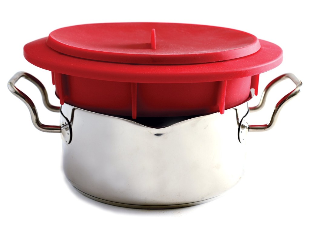 Norpro red silicone food steamer insert sitting on pot